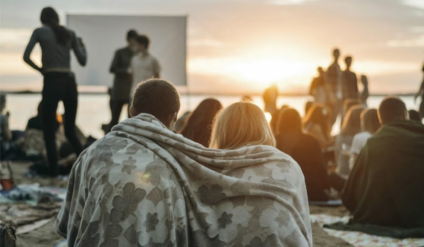 A couple watching a movie by the ocean | Beach movies