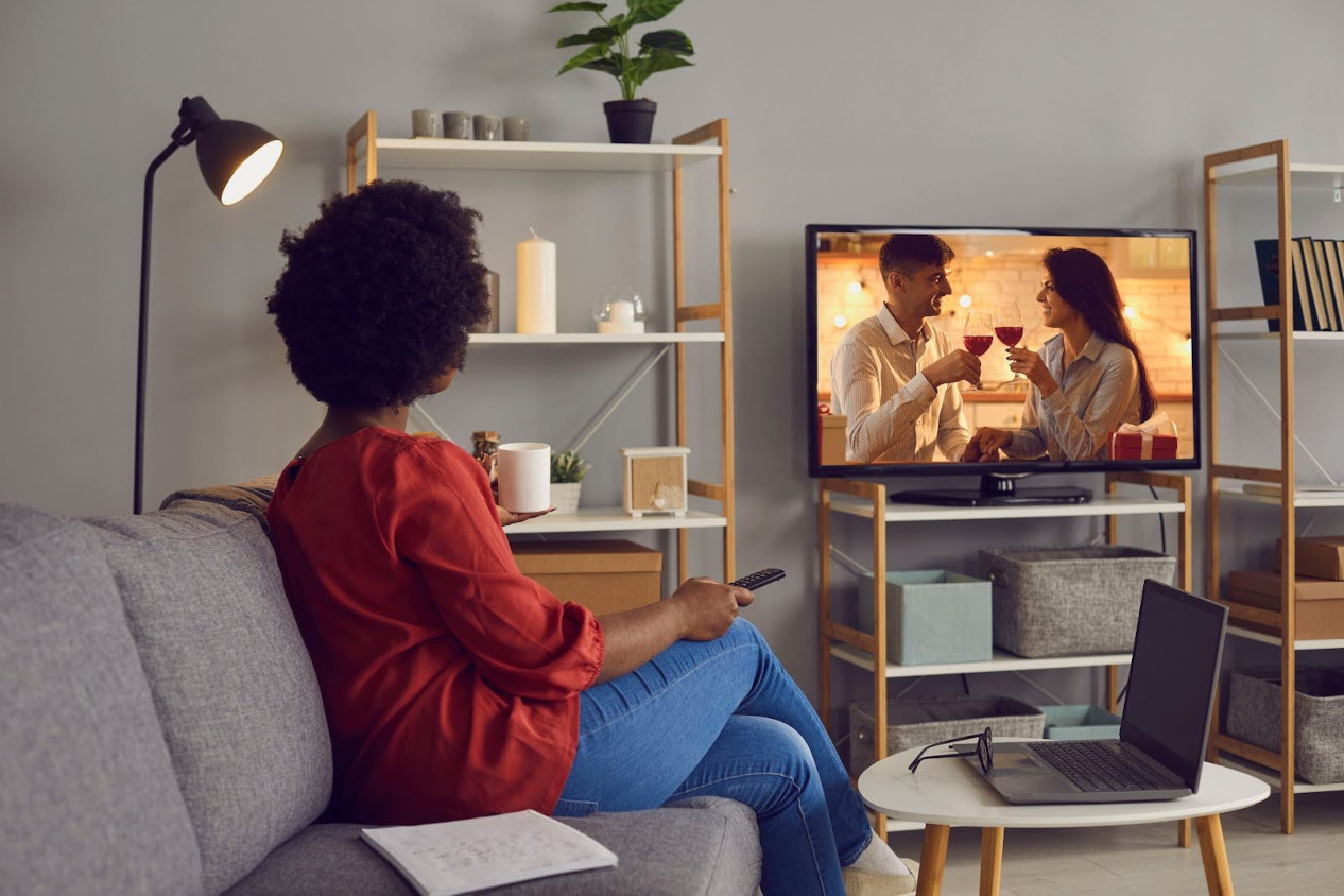 Woman sits on the couch while watching a movie depicting a couple drinking red wine | 7 Movies Like American Beauty